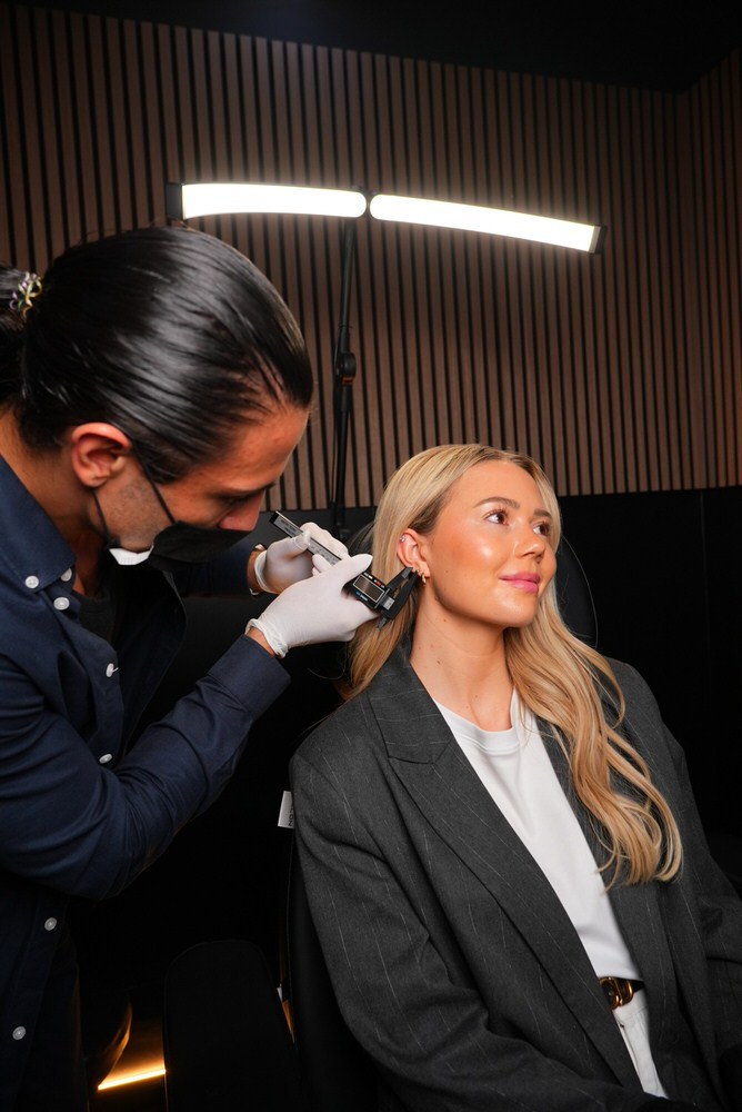 Piercer misst Ohr mit Digitalmessschieber bei der Beratung – TWINS-ATELIER HafenCity Hamburg